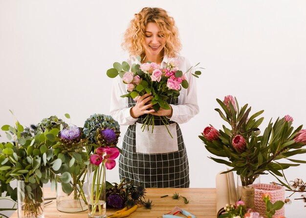 Glücklicher Florist des mittleren Schusses, der Blumen betrachtet