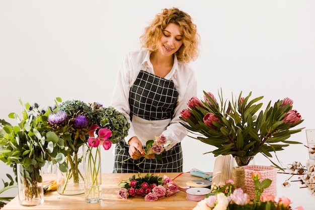 Kostenloses Foto glücklicher florist des mittleren schusses, der einen blumenstrauß vereinbart