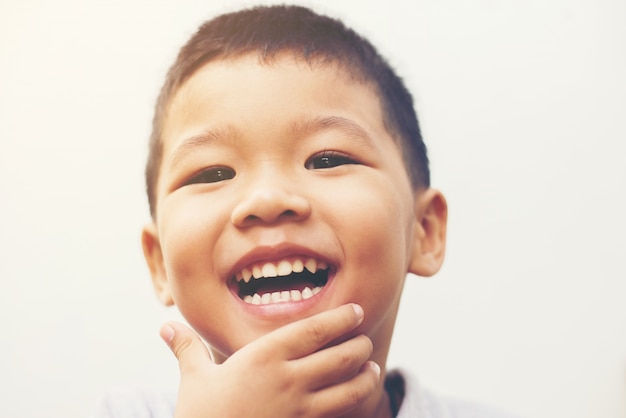 Glücklicher Junge lachen in die Kamera Porträt mit Isolat weiß ba suchen