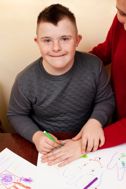 Glücklicher Junge mit Down-Syndrom-Zeichnung