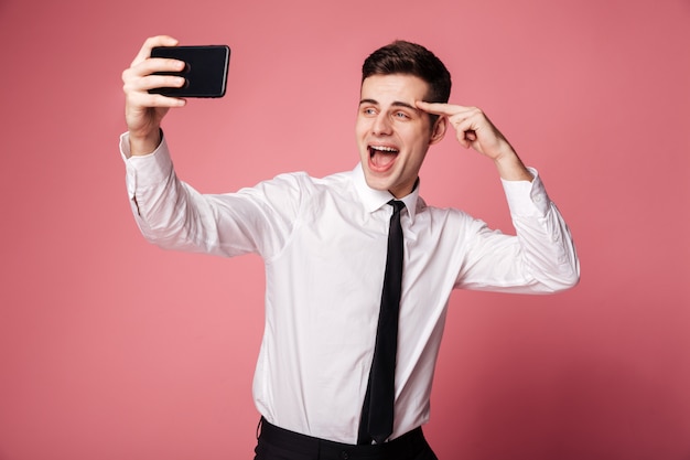 Glücklicher junger Geschäftsmann machen Selfie per Handy.