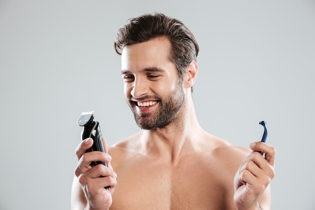 Kostenloses Foto glücklicher junger mann, der rasiermesser wählt
