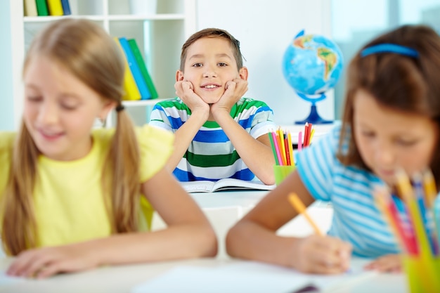 Glücklicher kleiner Junge mit Freunden zu studieren