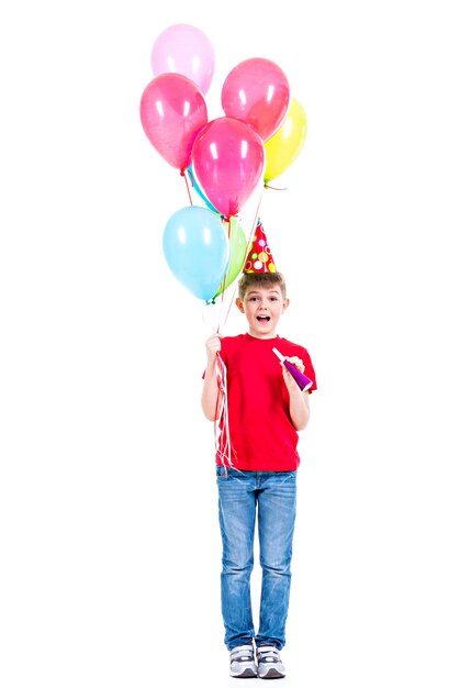 Glücklicher lächelnder Junge im roten T-Shirt, das bunte Luftballons hält - lokalisiert auf einem Weiß