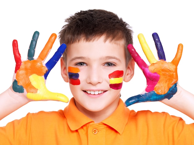 Glücklicher lächelnder Junge mit gemalten Händen und Gesicht im orange T-Shirt - auf einem weißen Hintergrund.