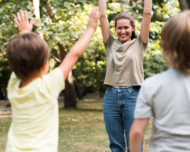 Kostenloses Foto glücklicher lehrer und kinder, die draußen trainieren