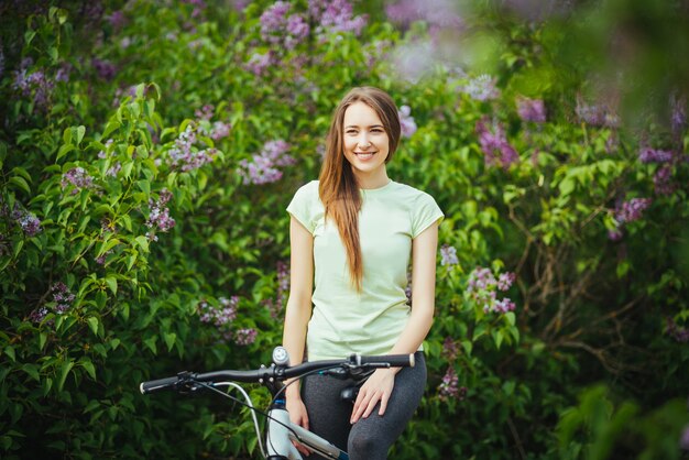 Glücklicher Mädchenradfahrer, der mit einer Mountainbike und steht. Abenteuerreisen.