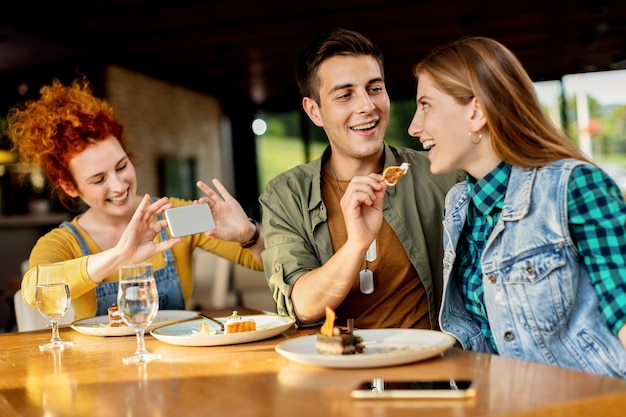 Glücklicher Mann, der Dessert mit seiner Freundin in einem Café teilt