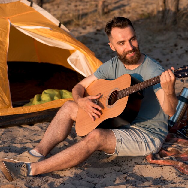 Glücklicher Mann, der die Gitarre spielt