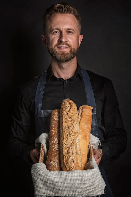 Kostenloses Foto glücklicher mann, der einen korb mit brot hält