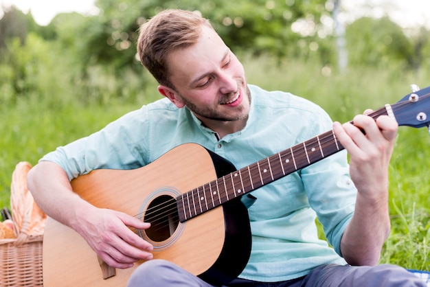 Kostenloses Foto glücklicher mann, der gitarre spielt