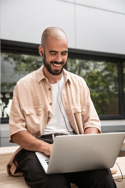 Kostenloses Foto glücklicher mann, der laptop hält