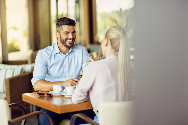 Kostenloses Foto glücklicher mann, der mit seiner freundin spricht, während er sich in einem café entspannt