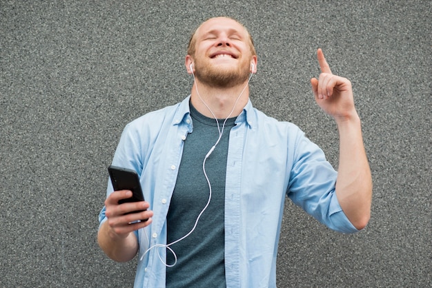 Glücklicher mann, der musik auf kopfhörern hört