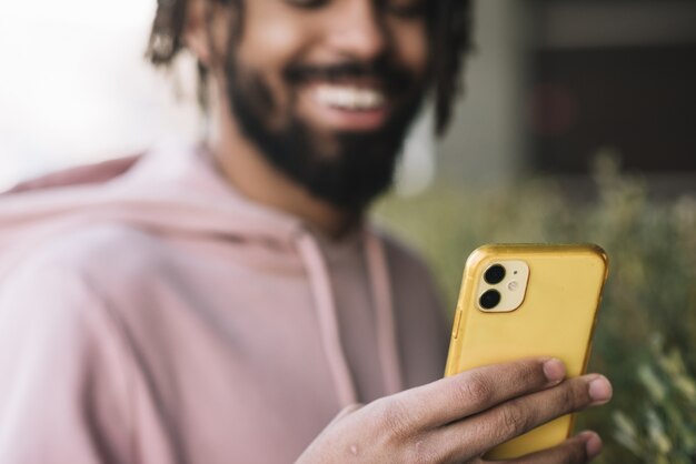 Glücklicher Mann, der Telefon ansieht