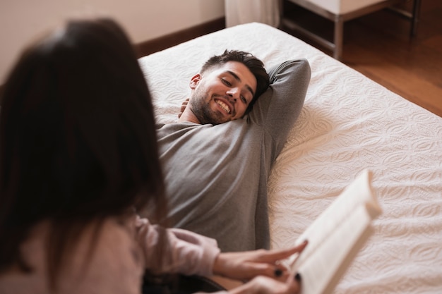 Glücklicher Mann, der über Buch lacht