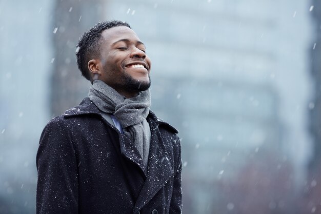 Glücklicher Mann im Schneefall