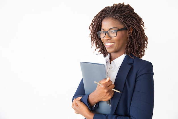 Glücklicher netter Büroassistent in den Gläsern, die Dokumente verwahren