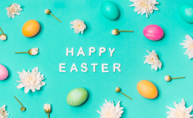 Glücklicher Ostern-Titel zwischen Satz hellen Eiern und den Blütenknospen
