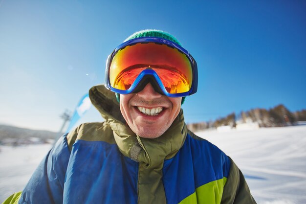 Glücklicher Snowboarder einen Tag im Schnee zu genießen