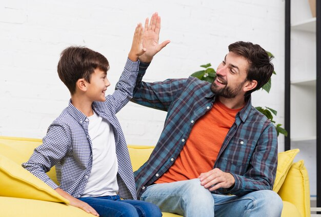 Glücklicher Sohn und Vater schlagen fünf