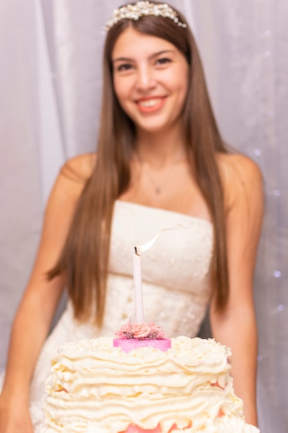 Glücklicher teenager, der ihren fünfzehnten geburtstag mit einem kuchen feiert