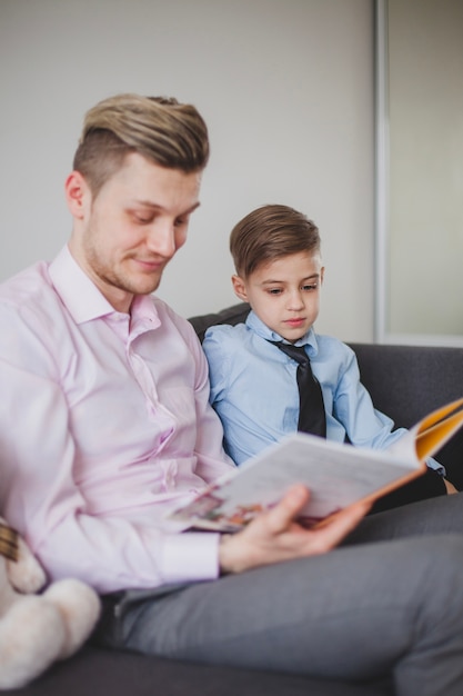 Glücklicher Vater mit seinem Sohn, der eine Geschichte liest