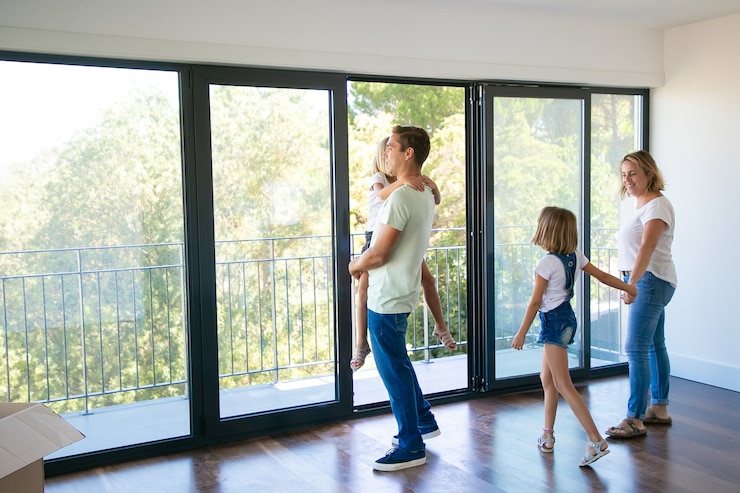 Kostenlose Foto glücklicher vater mit tochter, die nahe offenem balkon steht und lächelt