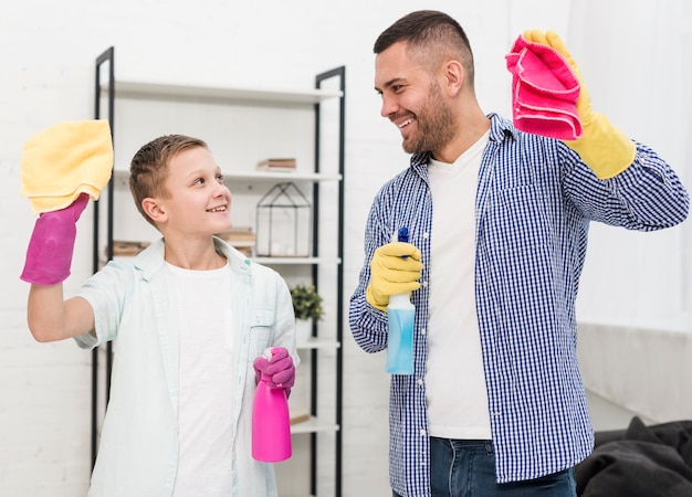 Glücklicher Vater und Sohn genießen die Reinigung des Hauses