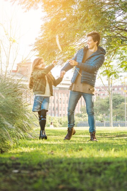 Glücklicher Vater und Tochter, die mit Schilf im Park spielt