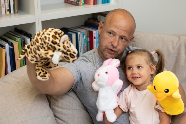 Glücklicher Vater und Tochter spielen mit Puppen