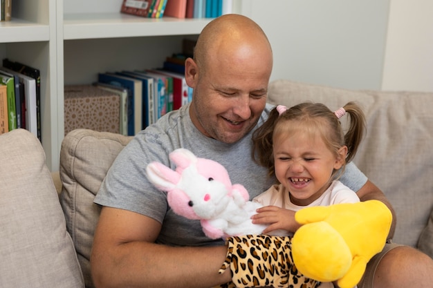 Glücklicher Vater und Tochter spielen mit Puppen