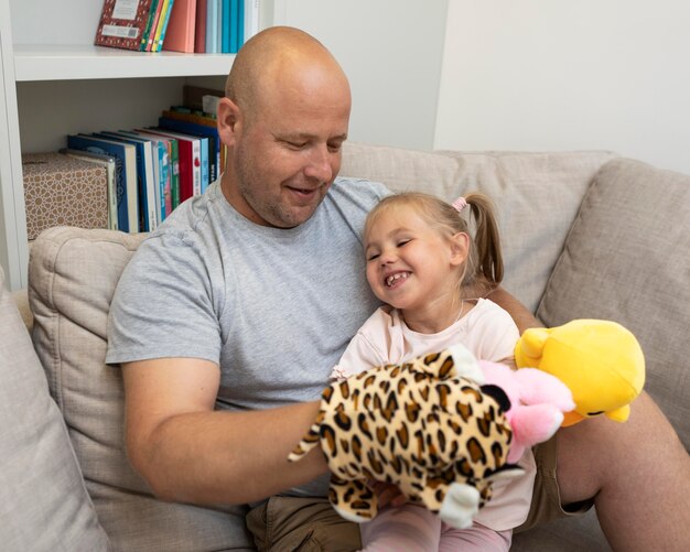 Glücklicher Vater und Tochter spielen mit Puppen