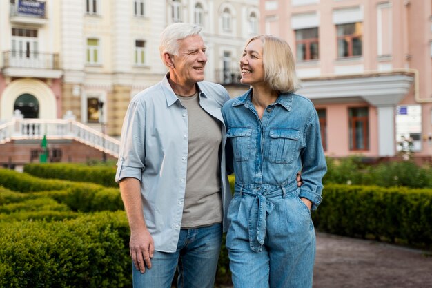 Glückliches älteres Paar, das ihre Zeit in der Stadt genießt, während es umarmt wird