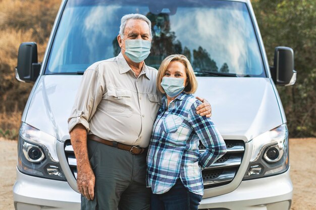 Glückliches älteres Paar, das vor Wohnmobil steht