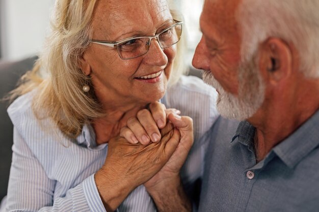 Glückliches älteres Paar in Liebe, Händchen haltend und miteinander reden Der Fokus liegt auf der Frau