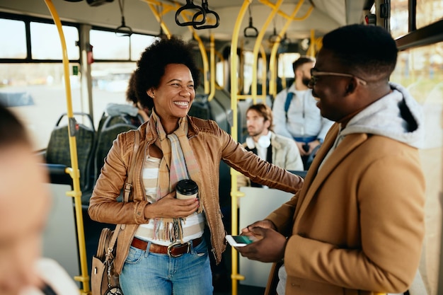 Glückliches afroamerikanisches Paar, das sich beim Pendeln mit dem Bus unterhält