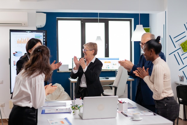 Glückliches aufgeregtes vielfältiges Team des Finanzteams im Konferenzraum nach erfolgreicher Strategie