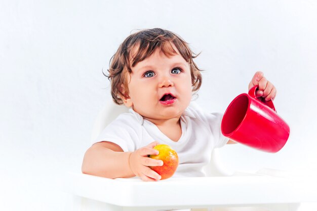 Glückliches Baby, das sitzt und isst