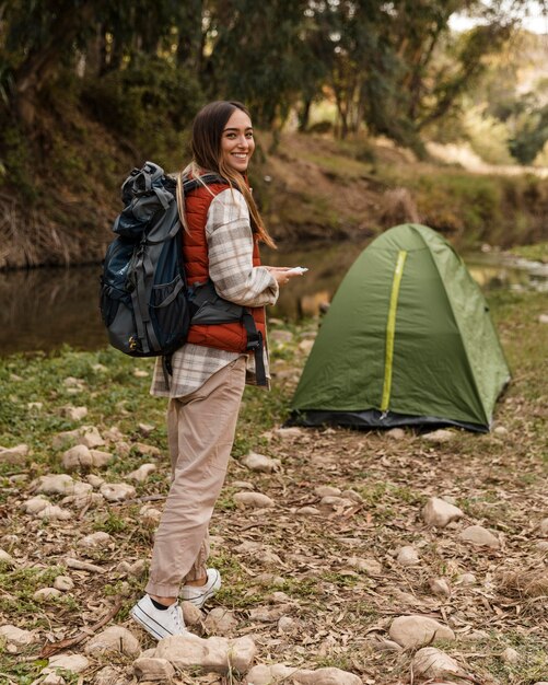 Glückliches Campingmädchen im Wald und im Zelt