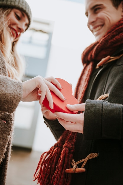 Glückliches Frau gifting Herz formte Kasten, um zu bemannen