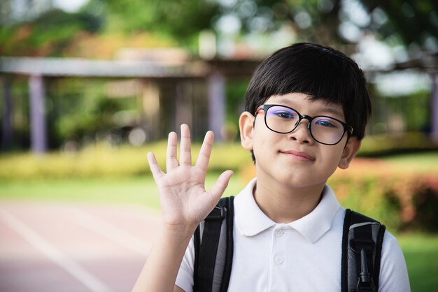 Glückliches Gehen jungen asiatischen Thailand-Jungen zur Schule