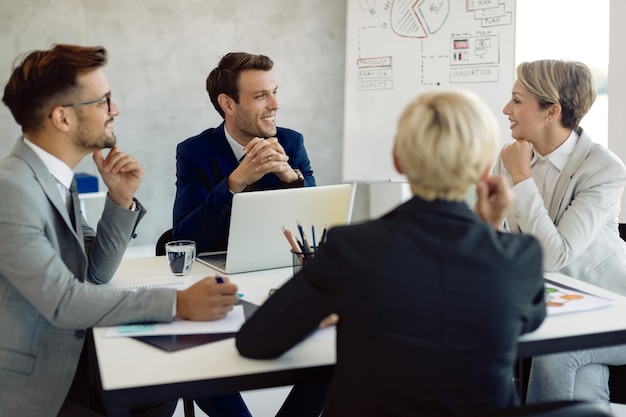 Kostenloses Foto glückliches geschäftsteam, das bei besprechungen im büro kommuniziert