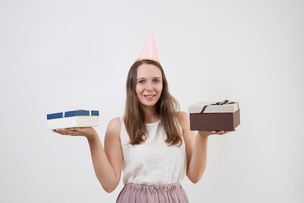 Glückliches hübsches Mädchen, das Geschenkboxen vergleicht und Kamera betrachtet