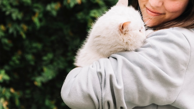 Kostenloses Foto glückliches junges mädchen, das mit ihrer katze aufwirft