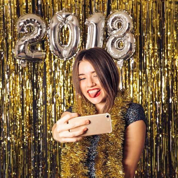 Glückliches junges Mädchen, das selfie auf Neujahrsparty nimmt