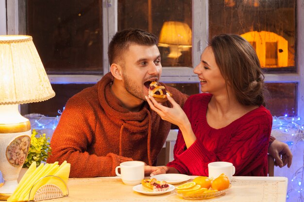 glückliches junges Paar mit Tassen Tee