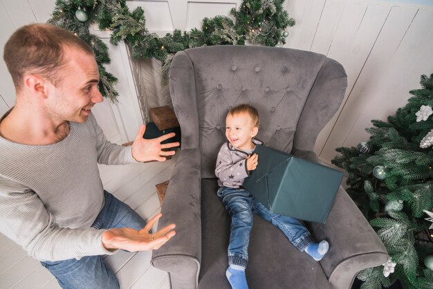 Glückliches Kind auf Couch mit Geschenk