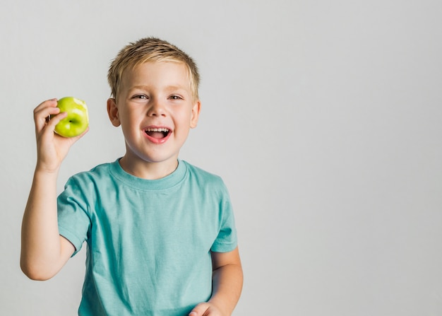 Glückliches Kind der Vorderansicht mit einem Apfel