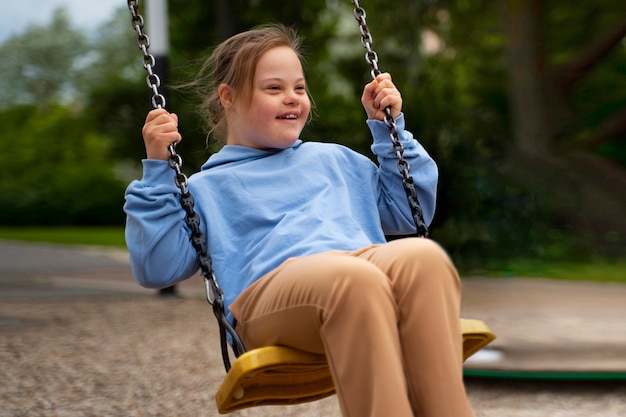 Glückliches Kind mit Down-Syndrom, das draußen spielt